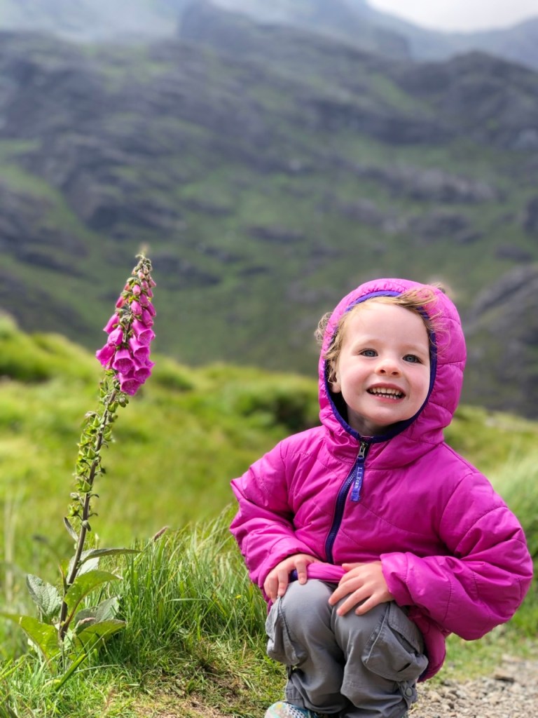 girl in pink jacket with pink wildflower